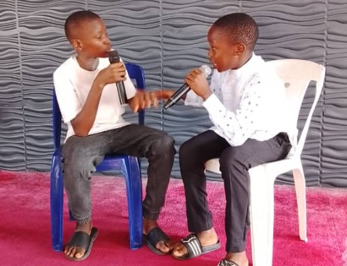 Two young people holding microphones during a youth debate